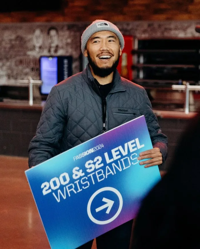 Guest services volunteer holding a wayfinding sign